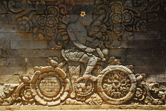 Radfahrer Tempel in Kubutambahan Mittelalterliche Steinmetzkunst mit einem Radfahrer und floralen Mustern.