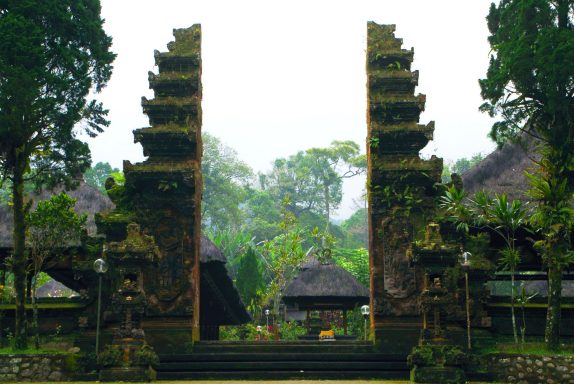 Eingangstor zum Tempel Batukaru Zwei hohe, mit Pflanzen bedeckte Tore in einem verwunschenen Garten.